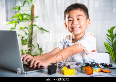 Un enfant asiatique apprend le codage et la programmation avec un ordinateur portable pour la voiture robot Arduino, les enfants qui tapent le code dans un ordinateur avec un jouet de voiture, UN duca À VAPEUR Banque D'Images