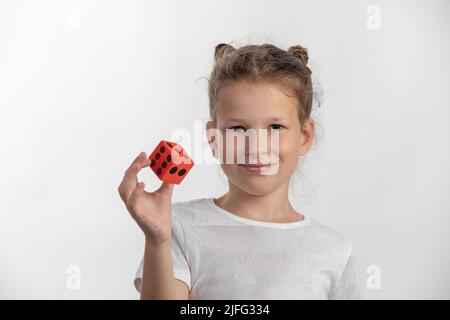 Jolie jeune fille tenant un grand, rouge mousse point dés - jouet - sur fond blanc Banque D'Images