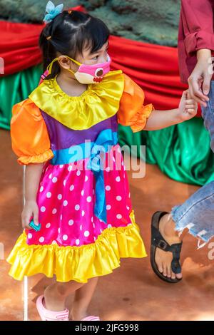 Jeune fille thaïlandaise en robe de fête avec facemask, Pattaya, Chon Buri, Thaïlande Banque D'Images