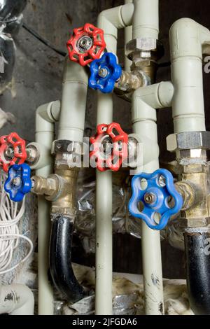 Tuyaux d'eau avec vannes rouges et bleues. Banque D'Images