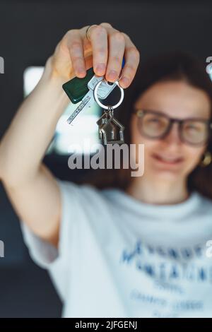 Femme heureuse locataire acheteur déménagement à la maison prendre selfie sur téléphone appareil photo avec des clés en main. Excitée jeune fille millénaire fière d'acheter plat faire vi Banque D'Images