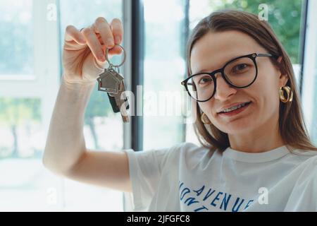 Femme heureuse locataire acheteur déménagement à la maison prendre selfie sur téléphone appareil photo avec des clés en main. Excitée jeune fille millénaire fière d'acheter plat faire vi Banque D'Images