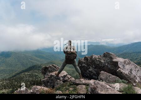 Un homme se dresse au sommet d'une montagne et jouit d'une vue magnifique sur la montagne. Prise sur le Mont Pidan, Russie. Photo de haute qualité Banque D'Images