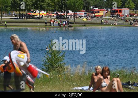 Accident de natation, opération à grande échelle, opération de sauvetage à Riemer Voir sur 3 juillet 2022. Les secouristes prennent soin d'une personne blessée à Riemer See (Bugasee), dans l'est de Munich. Les véhicules de secours de la police, des pompiers, des services d'urgence sont sur la rive et au premier plan, les baigneurs. Banque D'Images