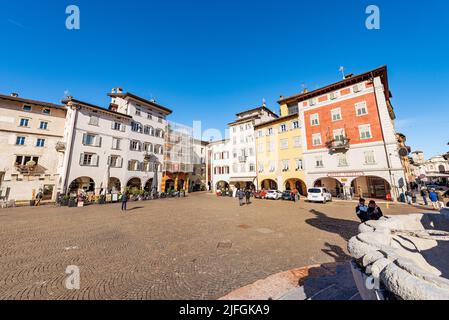 Piazza del Duomo, place de la cathédrale dans la ville de trente avec les maisons typiques. Les gens se promènent sur la place ou s'assoient dans les bars par une belle journée d'hiver. Banque D'Images