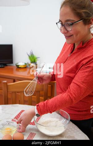Un cliché vertical d'une femme hispanique faisant un gâteau avec de la farine et des œufs à Barcelone Banque D'Images