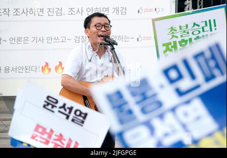 Protestation contre le président Yoon Suk-Yeol et la première dame Kim Keon-Hee, 2 juillet 2022 : Un chanteur sud-coréen et musicien indépendant Lee Gwang-Seok se produit lors d'un rassemblement aux chandelles contre le président Yoon Suk-Yeol et la première dame Kim Keon-Hee dans le centre de Séoul, en Corée du Sud. Les participants ont exigé d'organiser une poursuite spéciale pour enquêter sur l'implication présumée dans une affaire de manipulation du prix des actions par la première dame Kim Keon-Hee et ont demandé au Président Yoon de modifier ses politiques, qui ils insistent, ne communique pas avec les gens et a causé beaucoup de problèmes depuis son inauguration Banque D'Images