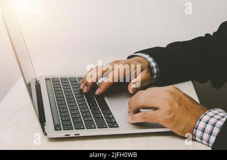 Homme mains travaillant sur les claviers d'ordinateur portable, la recherche sur Internet ou les achats en ligne ou l'envoi d'e-mails à leur bureau. Banque D'Images