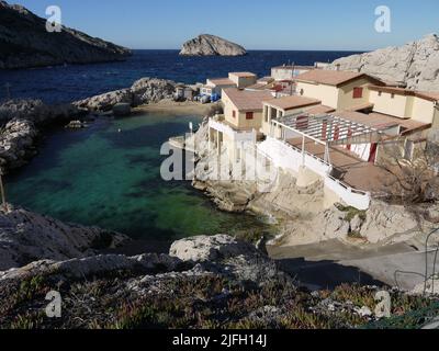 Une crique dans le sud de Marseille, avec un restaurant au milieu de l'eau et du paysage minéral dans les Goudes Banque D'Images