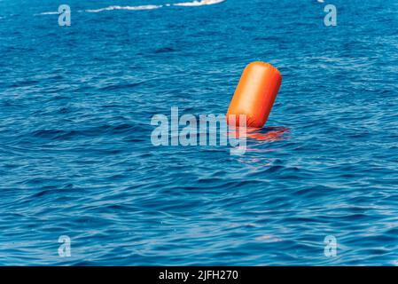 Une grande bouée gonflable orange à signal flottant dans la mer Méditerranée bleue, Golfe de la Spezia, Ligurie, Italie, Europe. Banque D'Images