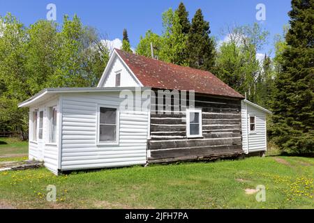 Des billes de tamarack exposées sur le presbytère à côté de l'église catholique Saint-Rosaire historique de 1865 sur la réserve Anishinaabe de Grand Portage, Minnesota. Banque D'Images