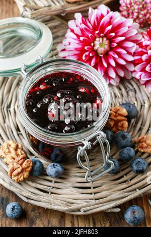 Pot de confiture de myrtilles et de fleurs de dahlia. Une alimentation saine Banque D'Images