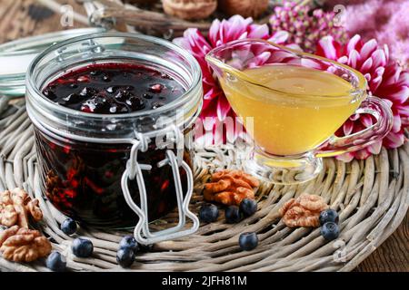 Pot de confiture de myrtilles, miel et fleurs de dahlia. Une alimentation saine Banque D'Images