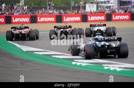 Mercedes Lewis Hamilton (en haut à droite) passe de la quatrième position à la deuxième en survolant Charles Leclerc (en haut à gauche) de Ferrari et Sergio Perez de Red Bull (en haut au centre) lors du Grand Prix britannique 2022 à Silverstone, à Towcester. Date de la photo: Dimanche 3 juillet 2022. Banque D'Images