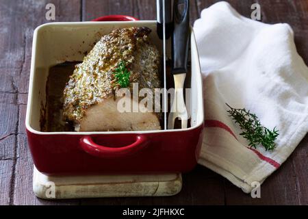 Filet de porc cuit avec des herbes, servi dans un plat de cuisson. Style rustique. Banque D'Images