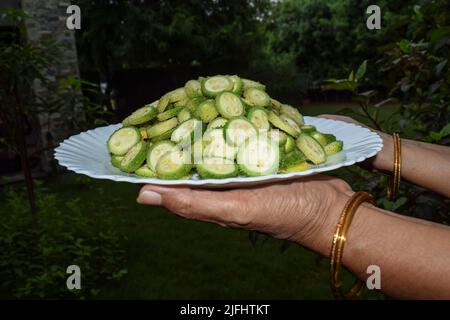 La plaque de conservation femelle de légumes de gourde épineux également connu sous le nom de gourdes de colonne ou Kantola sont des légumes sains saisonniers cultivés en Inde Asie, coupé dans sli Banque D'Images