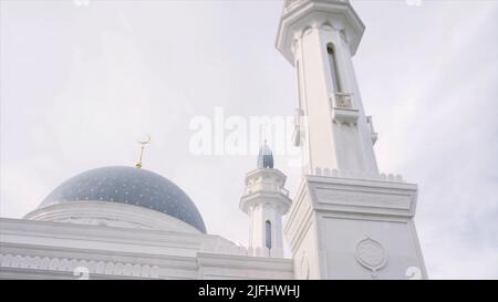 Magnifique mosquée blanche avec dôme bleu et tours sur fond ciel nuageux et lumineux. Scène. Concept de religion et de foi. Banque D'Images