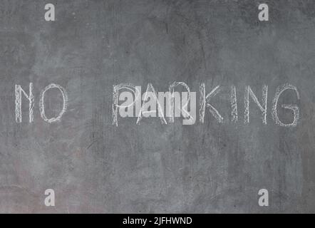 Mur de ciment sans panneau de stationnement écrit dans la craie Banque D'Images