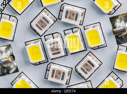 Diodes électroluminescentes électroniques sur la carte de circuit imprimé blanche de l'ampoule LED domestique. Gros plan de sources lumineuses jaunes ou claires de différentes températures de couleur. Banque D'Images