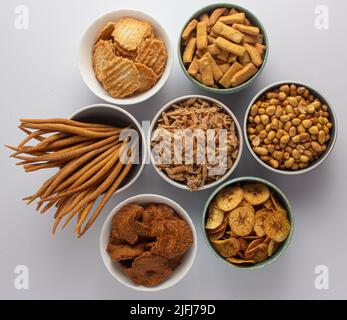 Une sélection d'en-cas nigérians - chips plantain, arachide, kokoro, gurundi, menton, bonbons à la noix de coco, kulikuli Banque D'Images