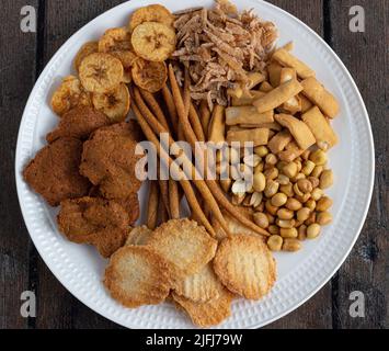Une sélection d'en-cas nigérians - chips plantain, arachide, kokoro, gurundi, menton, bonbons à la noix de coco, kulikuli Banque D'Images