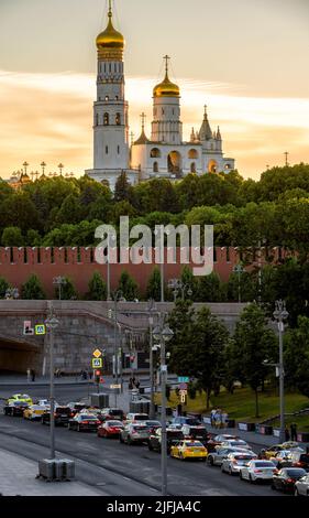 Moscou - 28 juin 2022 : Kremlin de Moscou et route de voiture au coucher du soleil, Russie. Vue verticale des vieilles cathédrales et églises ensoleillées, attractions touristiques de Mosco Banque D'Images