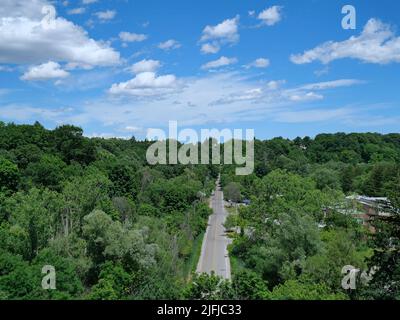 Vue depuis un pont sur une route de vallée à deux voies entourée d'arbres Banque D'Images