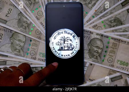 Inde. 03rd juillet 2022. Dans cette illustration, un logo RBI (Reserve Bank of india) apparaît sur un smartphone avec des illustrations de note en devise indienne en arrière-plan. Crédit : SOPA Images Limited/Alamy Live News Banque D'Images