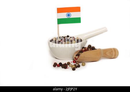 Mortier et pilon avec grains de poivre mélangés et drapeau de l'Inde sur fond blanc Banque D'Images