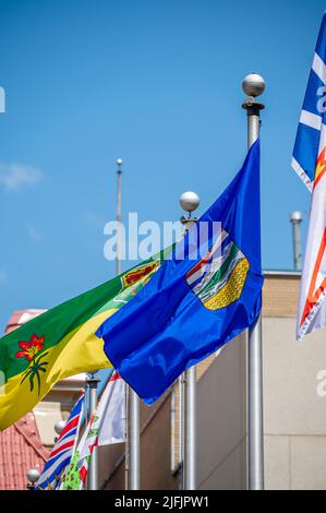 Plusieurs drapeaux provinciaux agitant dans le Wind inn Calgary, Alberta. Banque D'Images