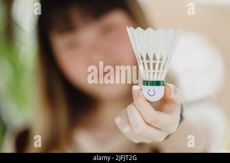 gros plan flou les gens main tenant Badminton Shuttercock avec le visage souriant heureux à la tête de balle. Banque D'Images