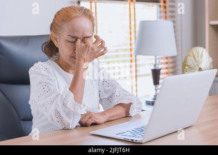 Femme yeux âgés douleur de l'asthme stress sinus fatigué souffrent de fatigue de travail dur avec l'écran d'ordinateur. Banque D'Images