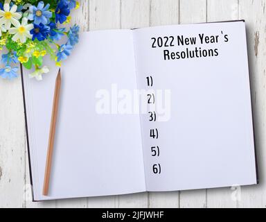 2022 liste des résolutions du nouvel an sur les notes avec un crayon sur une table en bois dans le bureau. Banque D'Images