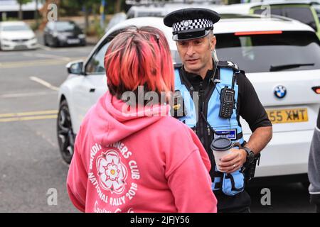 Un agent de liaison de la police s'adresse à un manifestant pour les derniers jours prévu sur la route à rouleaux sur le M62 , la station de service de Ferrybridge Pontefract, West Yorkshire, 04/07/22 Banque D'Images