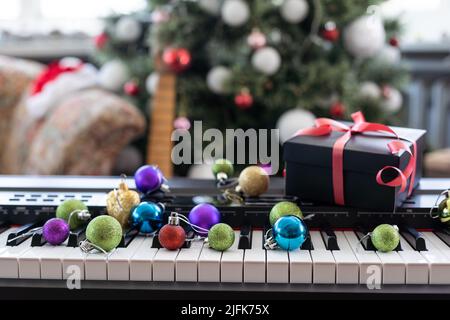 Composition du nouvel an sur un synthétiseur musical. Lumières d'une guirlande.Carte de vœux de joyeux Noël.Bonne année Banque D'Images