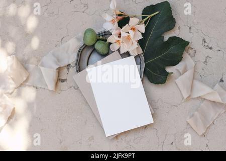 Marquage d'été, papeterie de mariage. Design méditerranéen. Carte de vœux, maquette d'invitation sur une assiette argentée vintage. Fruits à la figue, feuilles et oléander Banque D'Images