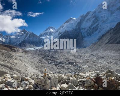 Cairn sur l'Everest base Camp trek sur la moraine au-dessus du glacier de Khumbu avec le Khumbu Icefall au loin. Banque D'Images