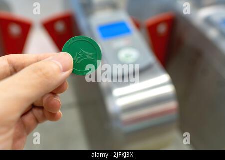 Taichung City, Taïwan - 3 juillet 2022 : en utilisant un jeton de billet aller simple, traversez la porte de sortie de la zone de paiement tarifaire du système de métro Taichung MRT. Banque D'Images