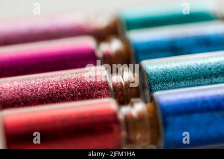 ensemble de différentes paillettes dans de petites bouteilles de verre Banque D'Images