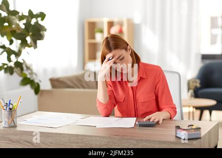femme avec calculatrice et papiers travaillant à la maison Banque D'Images