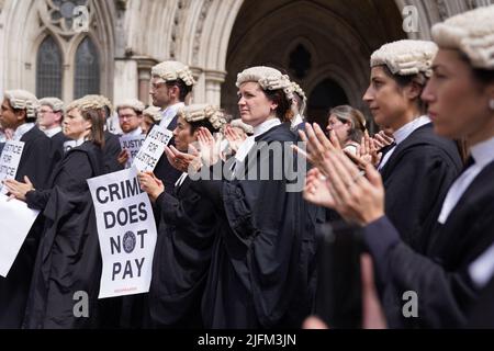 Les avocats de la défense criminelle se réunissent à l'extérieur des cours royales de justice à Londres pour appuyer l'action en cours de l'Association du Barreau criminel (ABC) sur le gouvernement, qui fixe des honoraires pour le travail de plaidoyer en matière d'aide juridique. Date de la photo: Lundi 4 juillet 2022. Banque D'Images