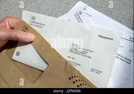 Gros plan de l'homme qui détient la lecture HMRC HM revenu et lettre de douane paiement de remboursement d'impôt Angleterre Royaume-Uni Grande-Bretagne Banque D'Images