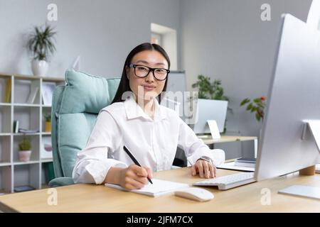 Portrait d'une jeune femme d'affaires asiatique belle et réussie, d'une employée souriante et regardant la caméra, comptable financier paperasserie. Banque D'Images