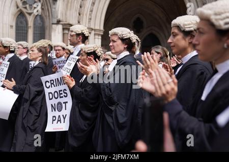 Les avocats de la défense criminelle se réunissent à l'extérieur des cours royales de justice à Londres pour appuyer l'action en cours de l'Association du Barreau criminel (ABC) sur le gouvernement, qui fixe des honoraires pour le travail de plaidoyer en matière d'aide juridique. Date de la photo: Lundi 4 juillet 2022. Banque D'Images