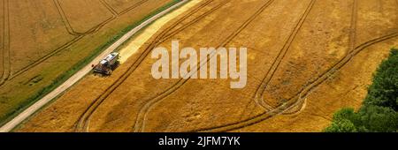 Pénurie de blé, prix d'échange élevés, mise en tas. Vue aérienne d'une moissonneuse-batteuse en cours de récolte. Bannière agricole. Banque D'Images