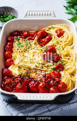 Fromage feta cuit avec des pâtes de tomate et de spaghetti dans un plat. Recette maison tendance. Banque D'Images