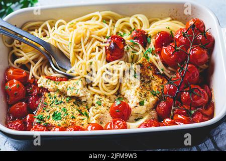 Fromage feta cuit avec des pâtes de tomate et de spaghetti dans un plat. Recette maison tendance. Banque D'Images