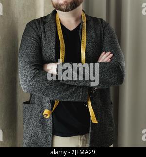 homme fier tailleur dans l'atelier. homme barbu brutal tailleur avec mètre ruban. Banque D'Images