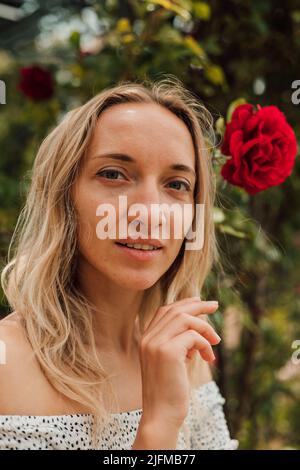 Portrait d'une jeune femme fatiguée près de roses rouges Banque D'Images