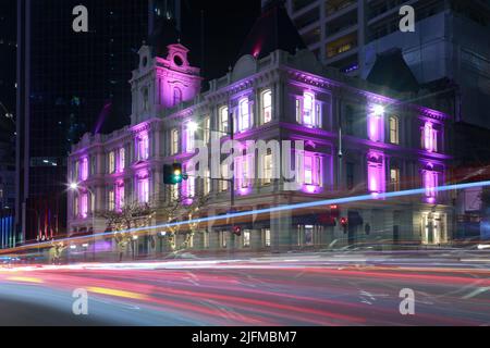 L'ancien bâtiment Customhouse de 1880s à Auckland, en Nouvelle-Zélande, est illuminé de couleur la nuit. Des sentiers de randonnée pédestre passent sur Customs Street Banque D'Images